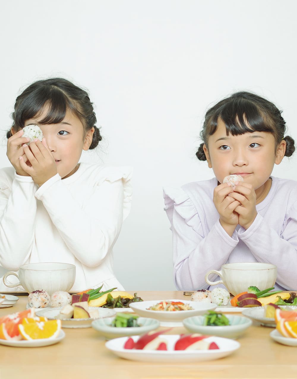 2人の子供が食卓に並んでいる様子