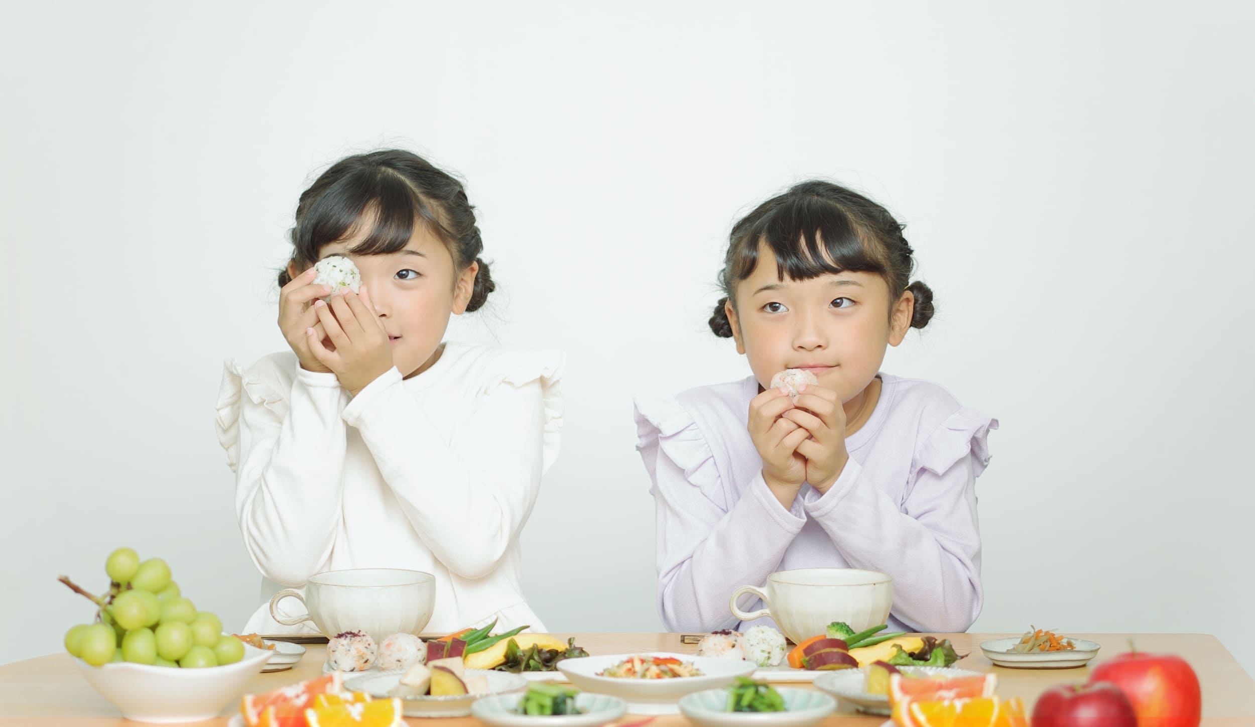 2人の子供が食卓に並んでいる様子